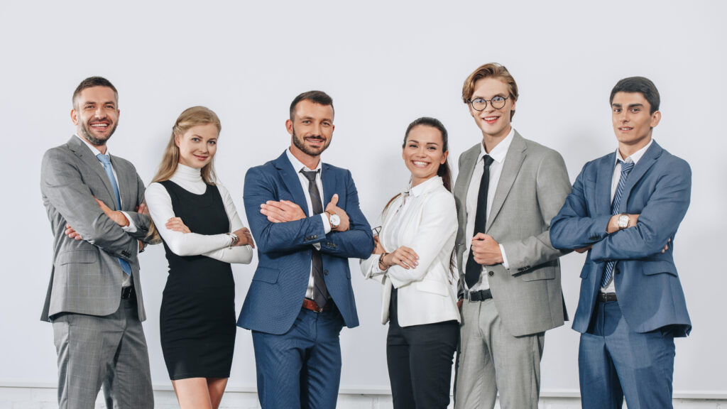 Business professionals standing together, smiling and looking confident.