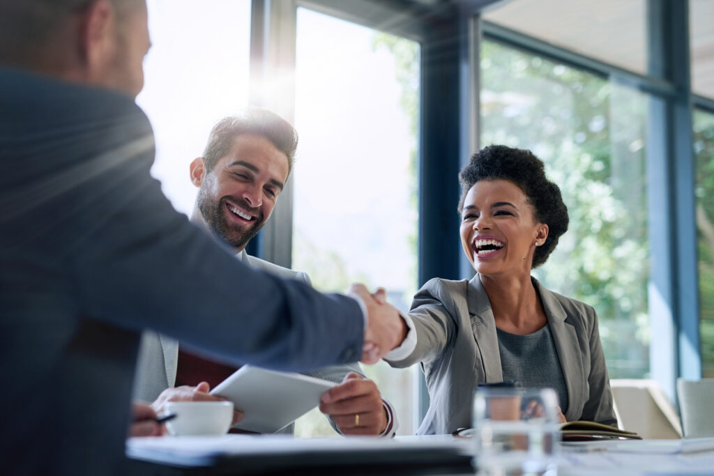 Two business professionals happily shaking hands, signifying a solid partnership
